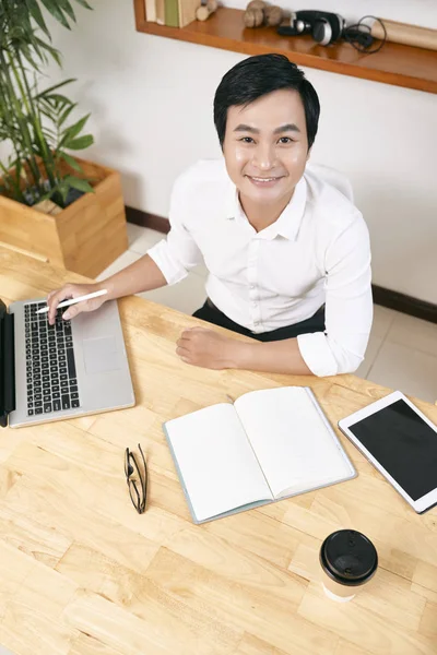明るい笑顔ベトナムのビジネスエグゼクティブは その上にラップトップ 計画とデジタルタブレットとオフィステーブルに座って — ストック写真