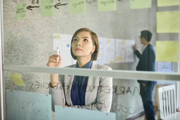 Pensive Jovem Senhora Negócios Vietnamita Olhando Para Inscrição Parede Vidro — Fotografia de Stock