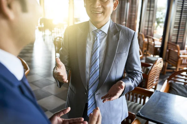 Sorrindo Asiático Empresário Terno Explicando Algo Para Seu Parceiro Café — Fotografia de Stock