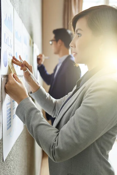 Young Vietnamese Businesswoman Analyzing Documents Hanging Office Wall Taking Notes — ストック写真