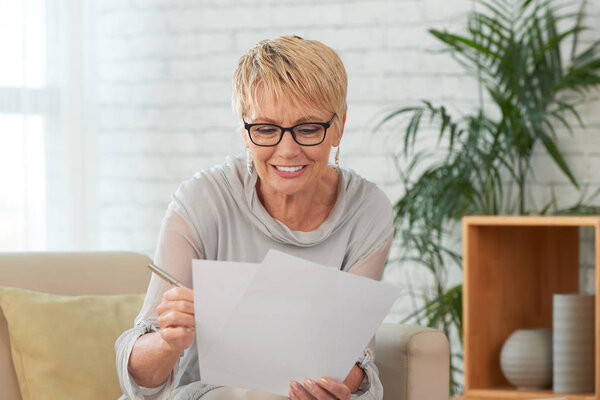 Portrait of smiling senior woman reading document