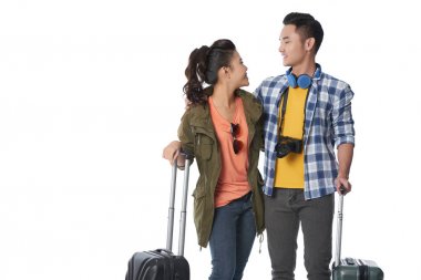 Vietnamlı erkek arkadaşı ve kız arkadaşı birbirlerine bakarak bavul ile