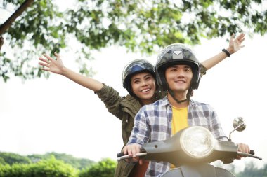 Mutlu heyecanlı Vietnamlı çift bir bisiklet yükselirken kask giyiyor