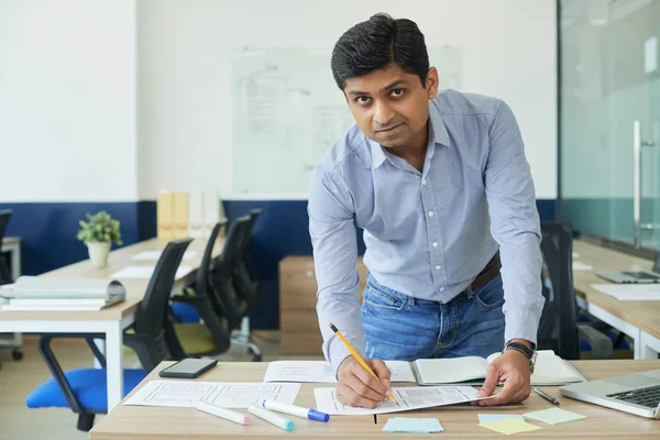 Θετικός Ινδός Επιχειρηματίας Που Λαμβάνει Σημειώσεις Έγγραφα Στο Τραπέζι Του — Φωτογραφία Αρχείου