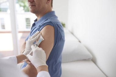 Hastanede erkek hastanın koluna doktor enjekte aşısı