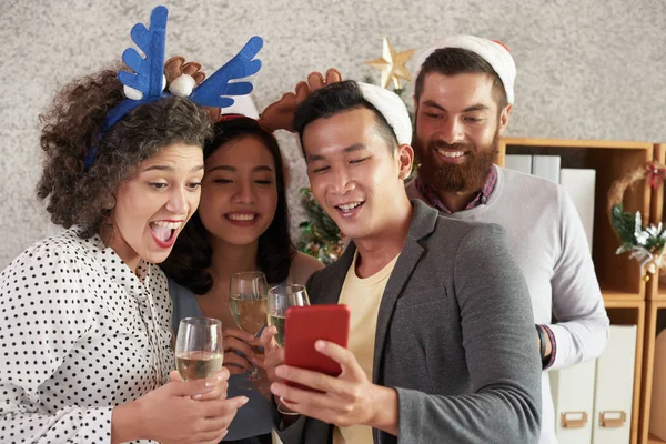 Cheerful Young Vietnamese Businessman Showing Coworkers Funny Christmas Videos Smartphones — Stock Photo, Image