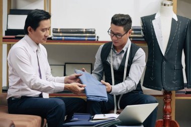 Profesyonel terzi mükemmel kalitede müşteri yeni kumaş gösteren