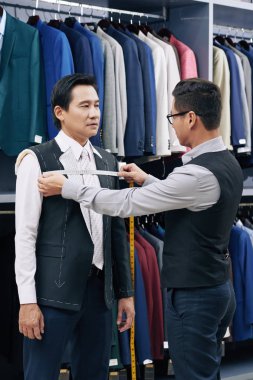 Onu ısmarlama takım elbise yaparken olgun adamın figürü ölçme Atölyesi işçisi