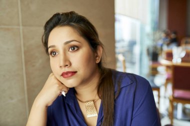 Genç ve güzel bir iş kadını pencereden bakıyor.