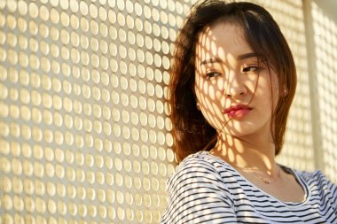 Delikli metal duvarda duran güzel kadın genç Vietnamlı kadının portresi