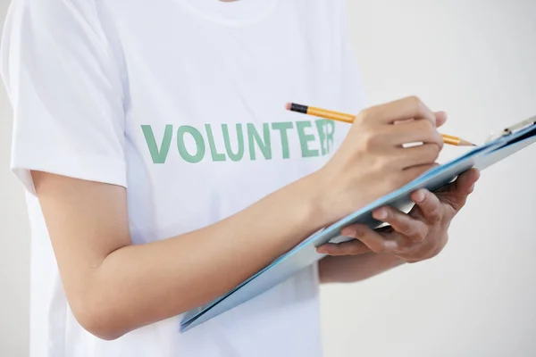 Beyaz Tişörtlü Kadın Gönüllünün Yakın Çekim Panosu Kalemle Notlar Alma — Stok fotoğraf