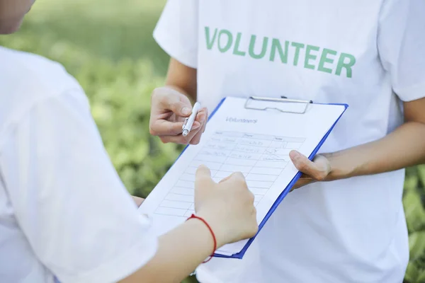 Erkek Gönüllü Nün Sözleşmeli Pano Tutması Arkadaşına Bunu Imzalaması Için — Stok fotoğraf