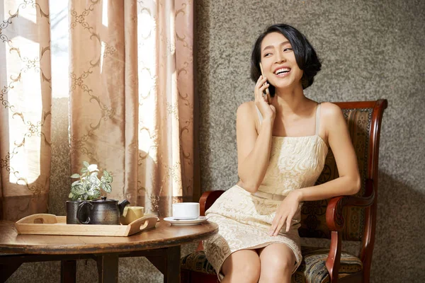 Attraktive Glückliche Junge Frau Sitzt Kaffeetisch Wohnzimmer Und Telefoniert — Stockfoto