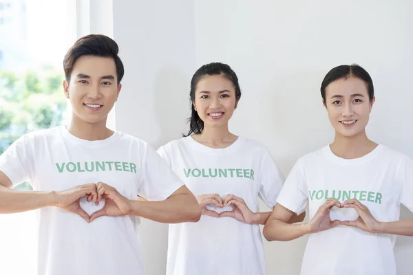 亚洲年轻人的肖像 他们是志愿者协会的成员 站在他们手中做一个心脏的形状 — 图库照片