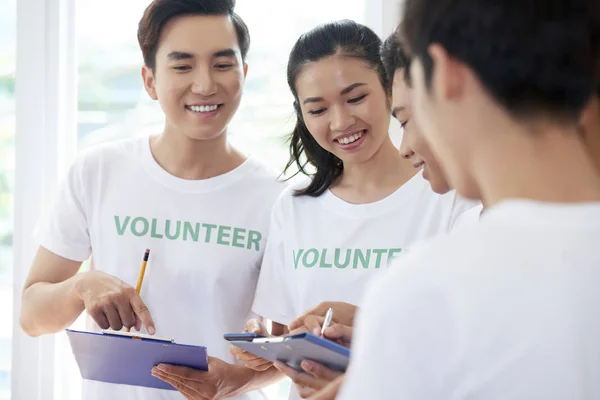 Sorridente Asiatica Volontaria Piedi Con Appunti Discutere Con Suoi Colleghi — Foto Stock