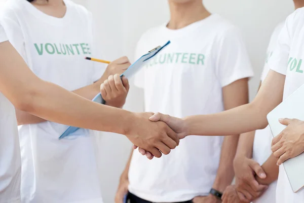 Крупный План Группы Добровольцев Работающих Документами Пожимающих Друг Другу Руки — стоковое фото