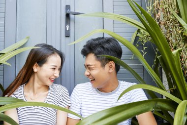 Vietnamlı erkek arkadaşı ve kız arkadaşı arka kapıda verandada otururken birbirlerine bakıyor