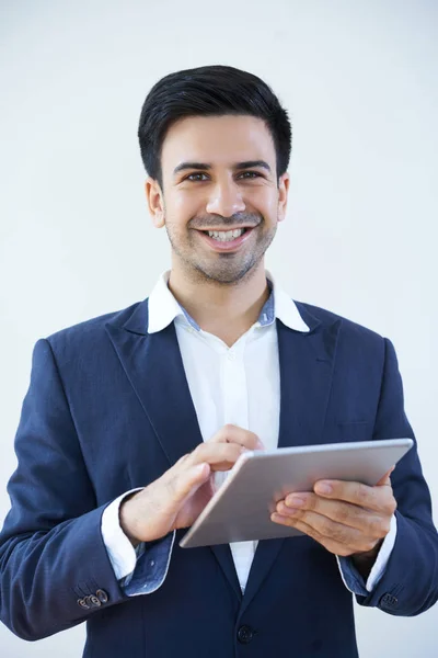 デジタルタブレットを持ち 白い背景の上にカメラで微笑むスーツで成功したビジネスマンの肖像画 — ストック写真