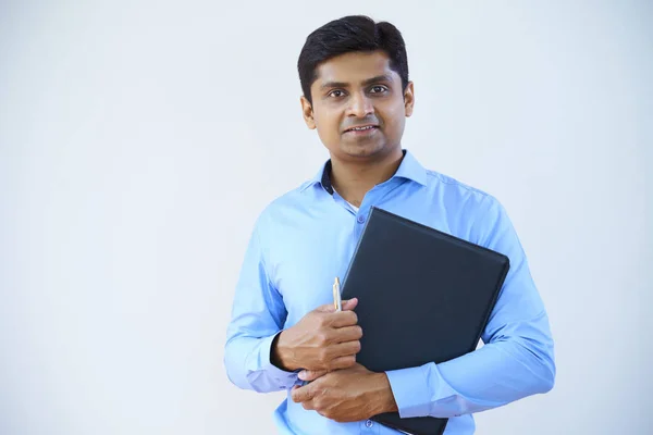 印度年轻商人的肖像 穿着蓝色衬衫 拿着文件文件夹 看着白色背景的相机 — 图库照片