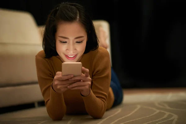 Glimlachend Jonge Vietnamese Vrouw Liggend Vloer Sms Met Vrienden Vriendje — Stockfoto