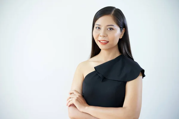 肖像亚洲美丽的女人站在黑色礼服与手臂交叉和微笑在相机的白色背景 — 图库照片