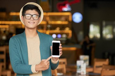 Boş ekran ile akıllı telefon gösteren neşeli genç Asyalı adam Portresi