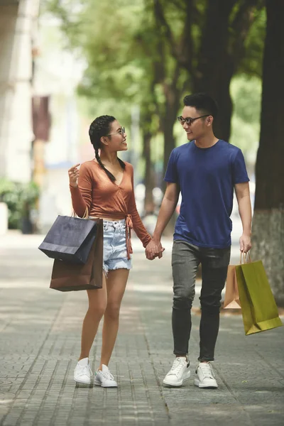 快乐的亚洲夫妇拿着购物袋手牵手 走在城市的街道上 — 图库照片