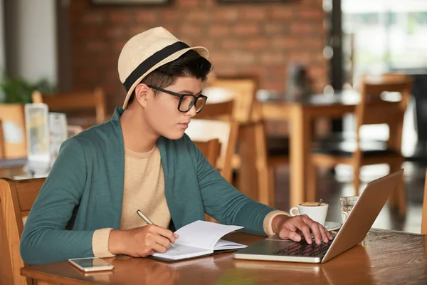 Junger Mann Sitzt Cafétisch Liest Daten Auf Laptop Bildschirm Und — Stockfoto