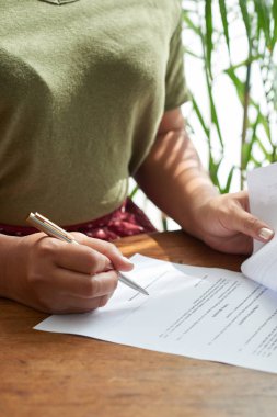 Rahat kafede masada otururken önemli kağıtları imzalamak için kalem kullanarak Kırpma bayan