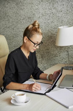 İş kadını tablet bilgisayarda bazı bilgileri okuma ve belge doldurma