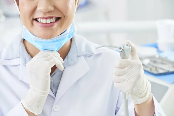 Zbliżenie Kobiecego Dentysty Uśmiechając Się Trzymając Wiertarkę Dentystyczne Rękawicach Ochronnych — Zdjęcie stockowe