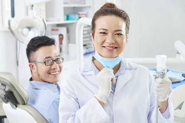 Retrato Dentista Asiática Uniforme Sosteniendo Taladro Dental Sonriendo Mientras Trata —  Fotos de Stock