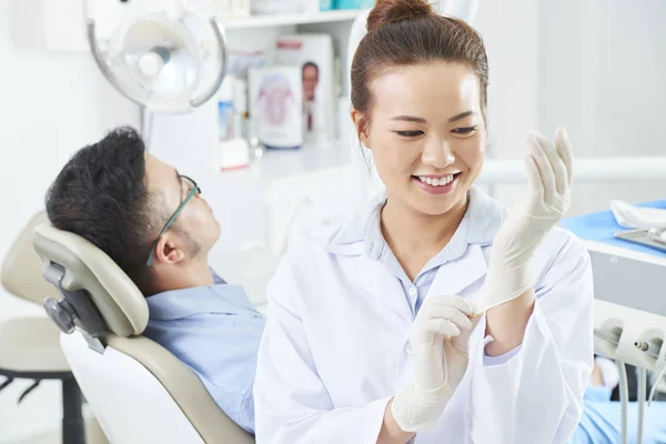 Sonriente Dentista Joven Con Guantes Protectores Trabajar Mientras Paciente Masculino —  Fotos de Stock