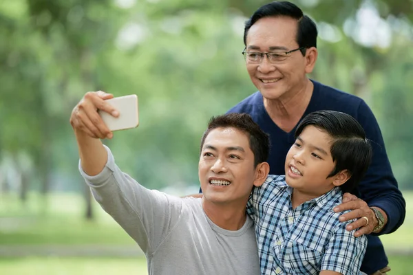 彼の息子と高齢の父親とセルフを取る中年のベトナム人男性 — ストック写真