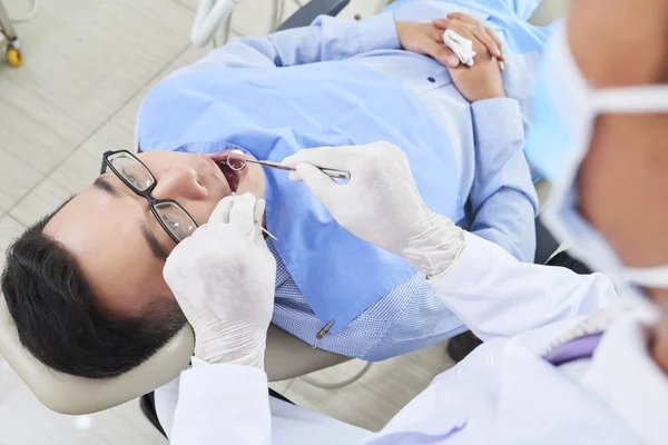 Jovem Deitado Cadeira Dentária Abrindo Boca Enquanto Dentista Luvas Proteção — Fotografia de Stock