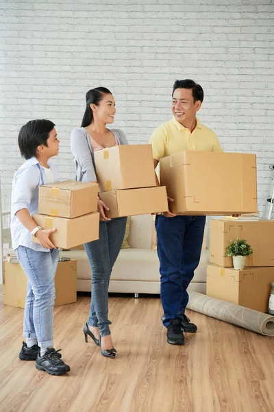 彼らの新しいアパートに立っている箱のスタックと陽気なアジアの家族 — ストック写真