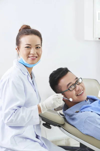 Портрет Молодого Стоматолога Уніформі Посміхаючись Камеру Під Час Медичної Процедури — стокове фото