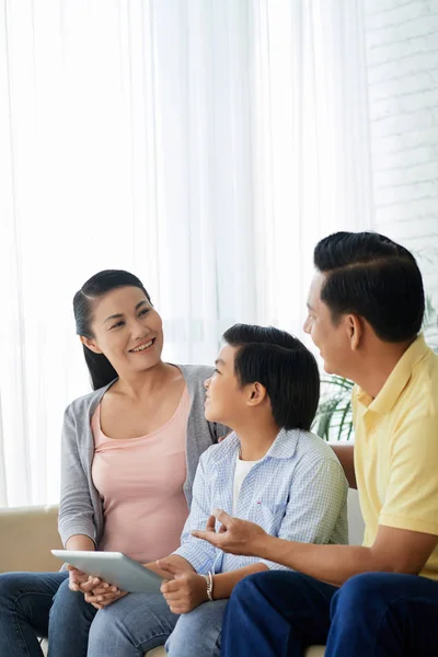 Vrolijke Vietnamese Familie Zittend Bank Bespreken Van Nieuwe Toepassing Tablet — Stockfoto