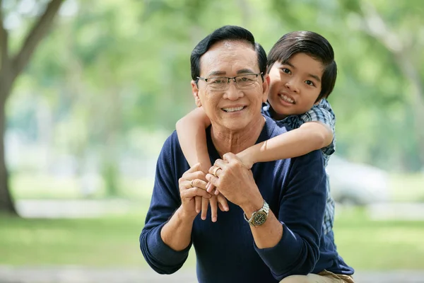 Feliz Niño Pequeño Abrazando Abuelo Por Detrás —  Fotos de Stock