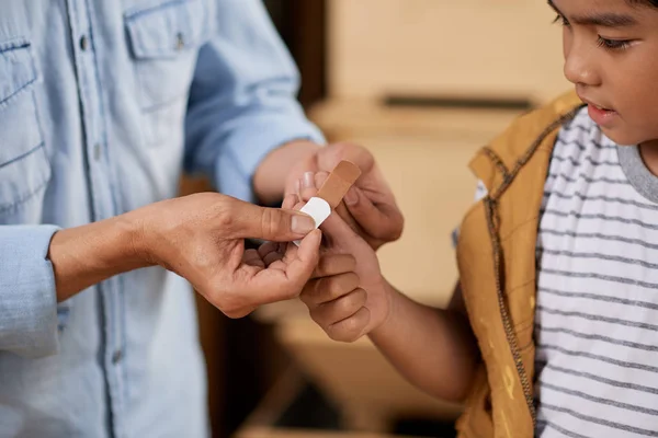 Pai Colocando Band Aid Dedo Seu Filho Pequeno — Fotografia de Stock