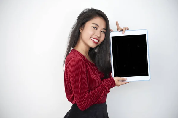 アジアの若いブルネットの肖像画は 立って デジタルタブレットの空の画面を示し 白い背景の上にカメラで微笑んで — ストック写真