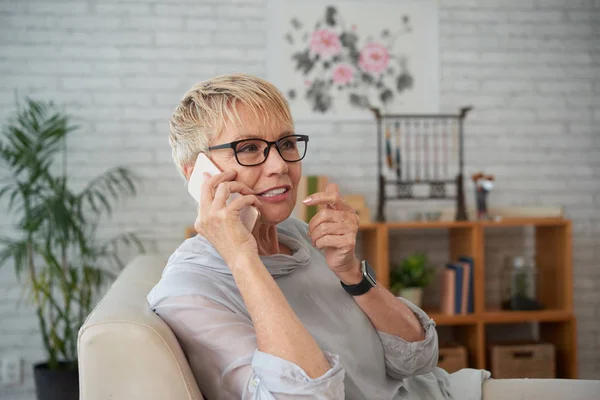 Mulher Madura Bonita Falando Telefone Celular Sorrindo Enquanto Descansa Sofá — Fotografia de Stock