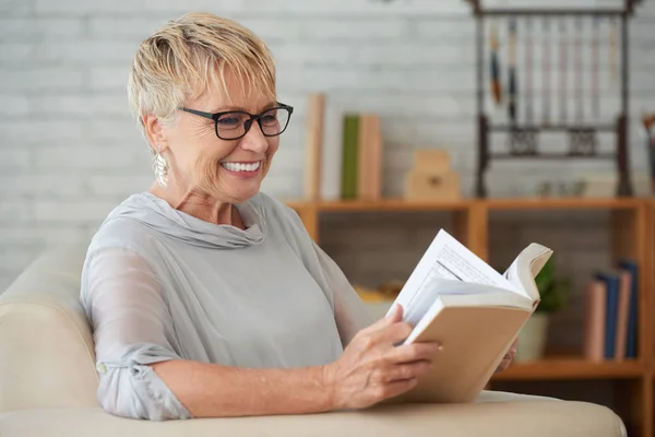 Senior Happy Woman Eyeglasses Relaxing Sofa Living Room Interesting Book — Stock Photo, Image