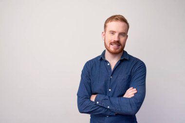 Genç kırmızı saçlı adam kolları çapraz ve beyaz arka plan üzerinde izole kamera gülümseyerek kot ceket ayakta portresi