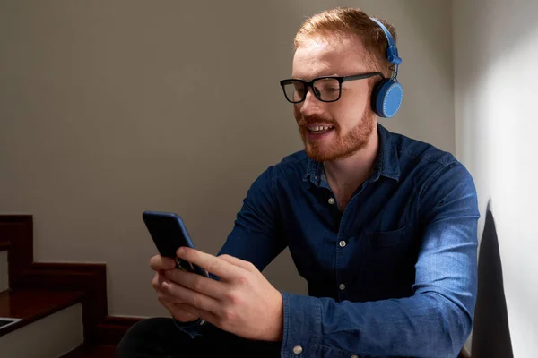 Uśmiechnięty Casual Człowiek Okularach Siedzi Schodach Słuchawkach Słuchanie Muzyki Jego — Zdjęcie stockowe