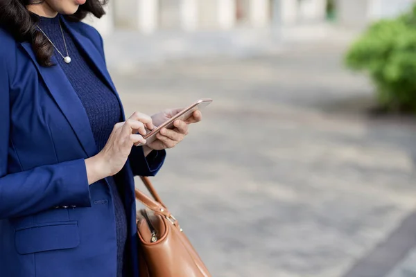 Mavi Ceketli Genç Kadının Akıllı Telefonundaki Metin Mesajlarını Kontrol Edeminin — Stok fotoğraf