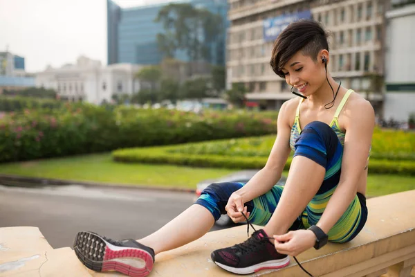 Улыбающаяся Молодая Вьетнамская Женщина Завязывает Шнурки Перед Тренировками Открытом Воздухе — стоковое фото