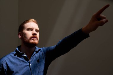 Kızıl saçlı sakallı asi adam bazı siyasi hareketi desteklemek için sol elini yükseltiyor