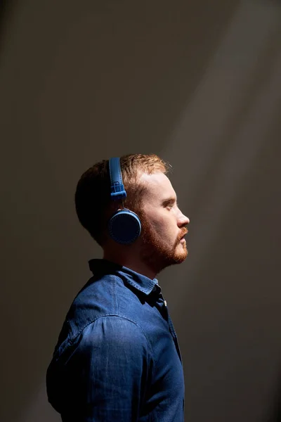 Молодий Чоловік Навушниках Стоїть Темній Кімнаті Слухає Музику — стокове фото