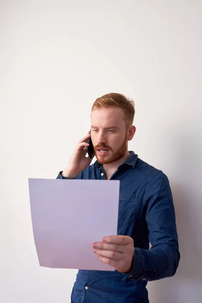 Biznesmen Czytanie Ważnego Dokumentu Podczas Rozmowy Telefon Komórkowy — Zdjęcie stockowe